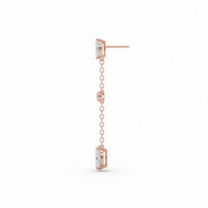 Rose gold earring with chain and clear gemstones on a white background